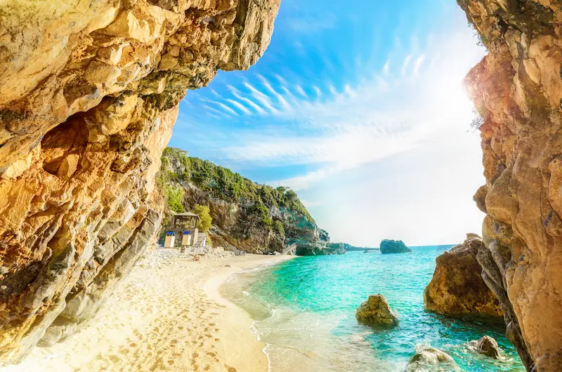 Plaja Mylopotamos cu stânci ocru și peșteră naturală, insula Corfu Grecia - bilete avion TravelTheme