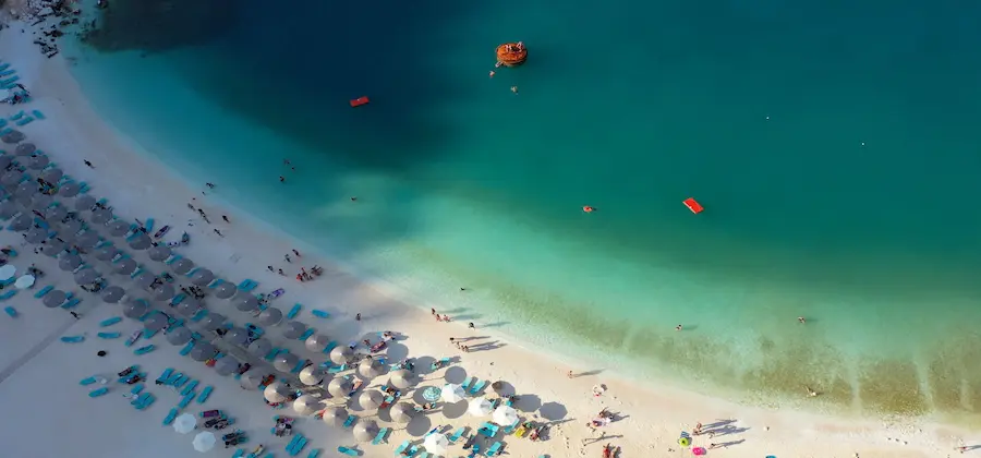 Pachis Beach cu umbrele albastre și ape cristaline pe coasta insulei Thassos, Grecia - oferte hoteluri TravelTheme